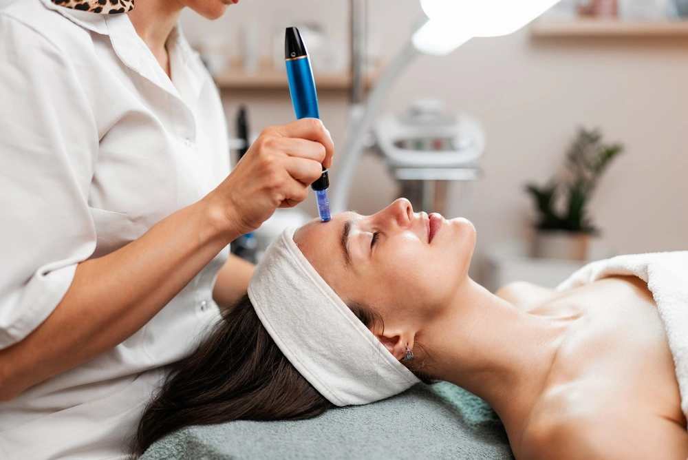 Provider using SkinPen microneedling device on patient's face during treatment